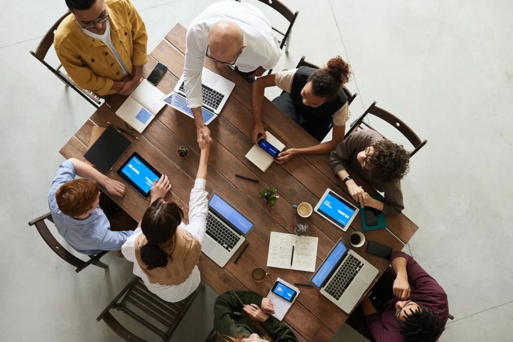 A group of professionals meeting at a table with various defices