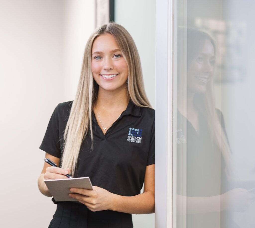 A saltech employee standing the the doorway holding a notepad