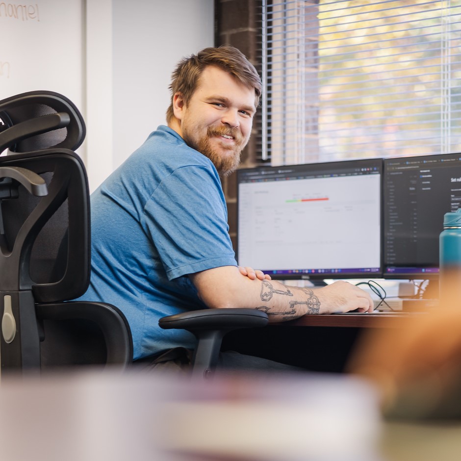 A Saltech employee working at his desk and looking back over his shoulder