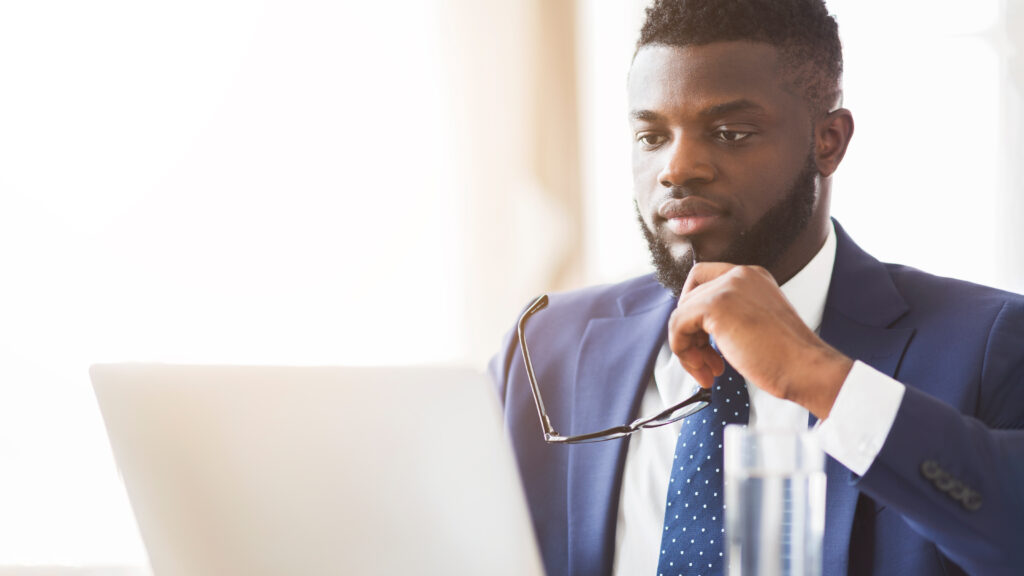close up of man in suit reading reports on laptop 2026 01 08 23 15 29 utc
